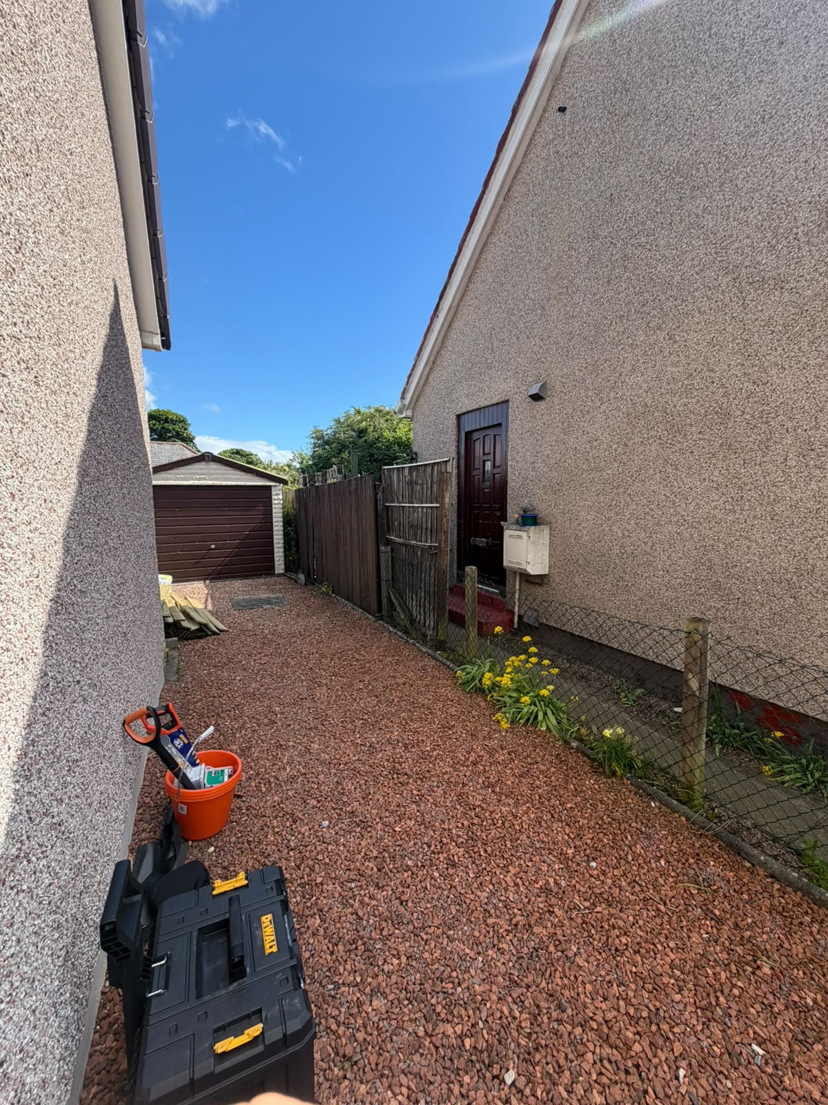 Newly laid decorative red gravel path running alongside a Highland home