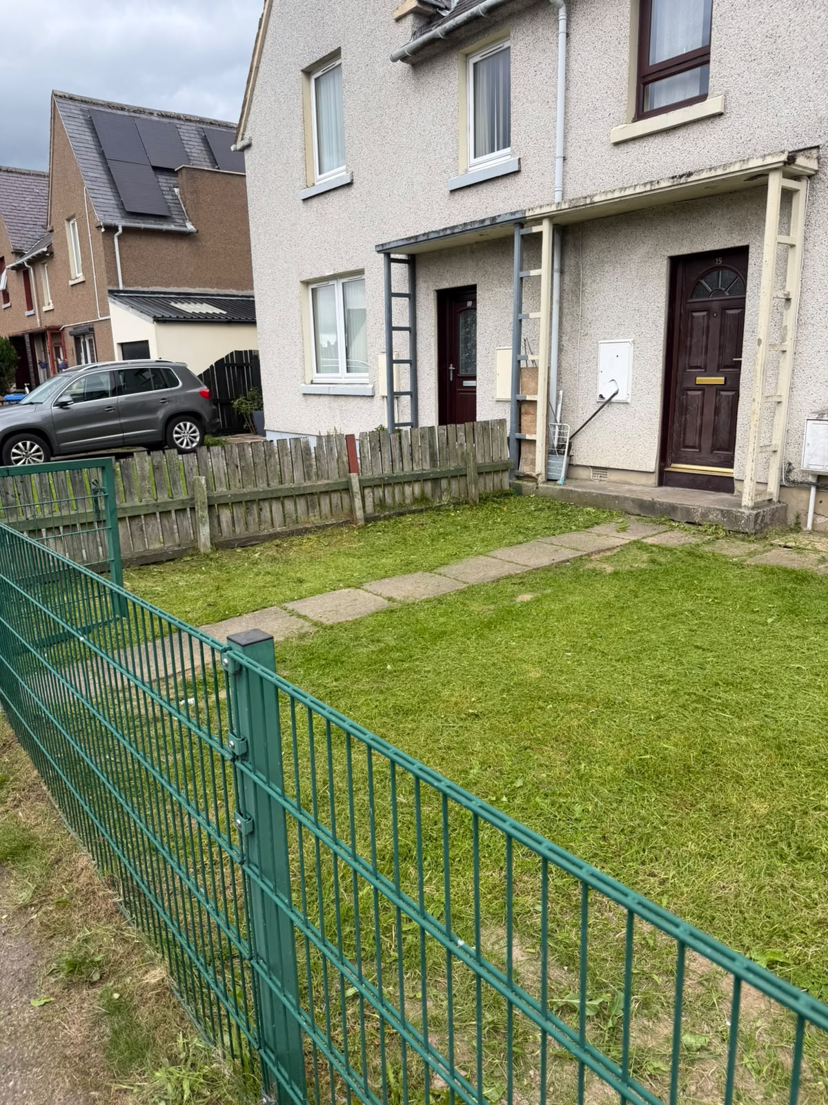 Overgrown front lawn cut back, after